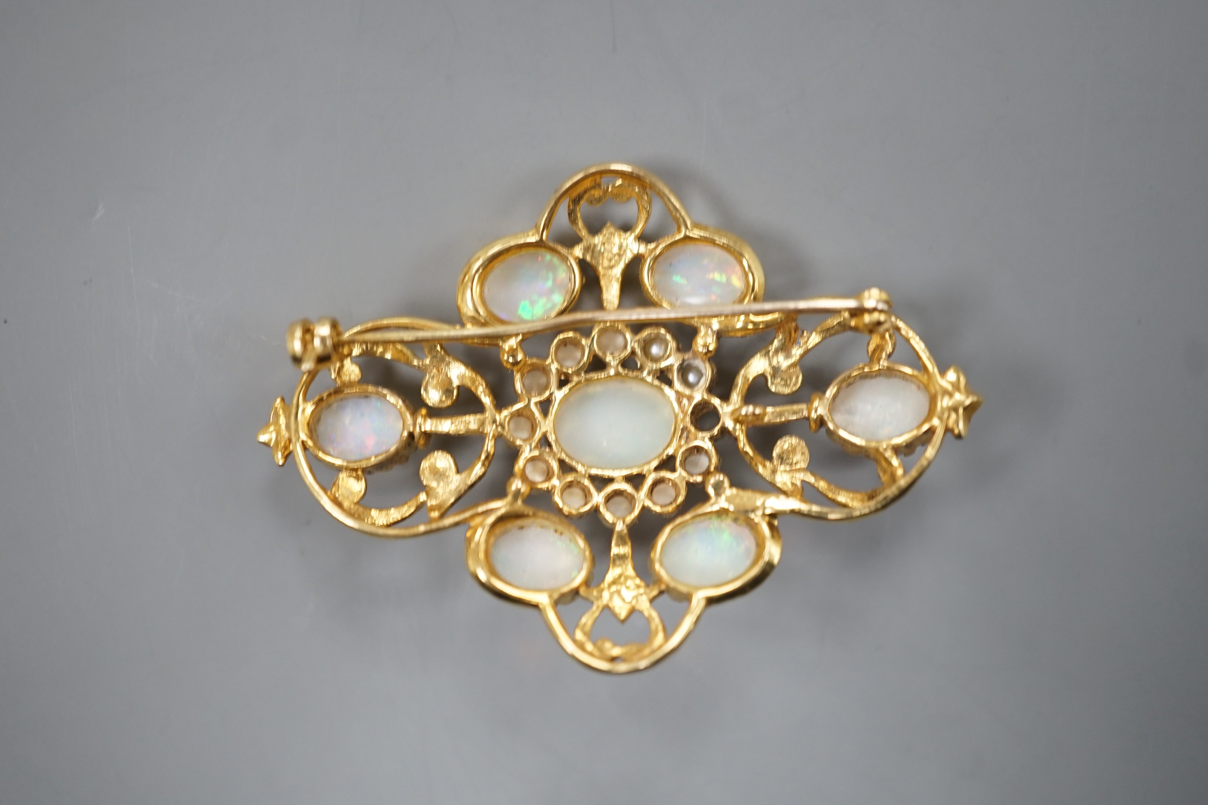 An early 1970's 9ct gold, graduated oval white opal and split pearl set brooch, of quatrefoil shape (pearl missing), 48mm, gross weight 9.3 grams.